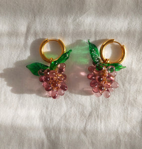 Handmade gold hoop earrings with a glass grape charm.